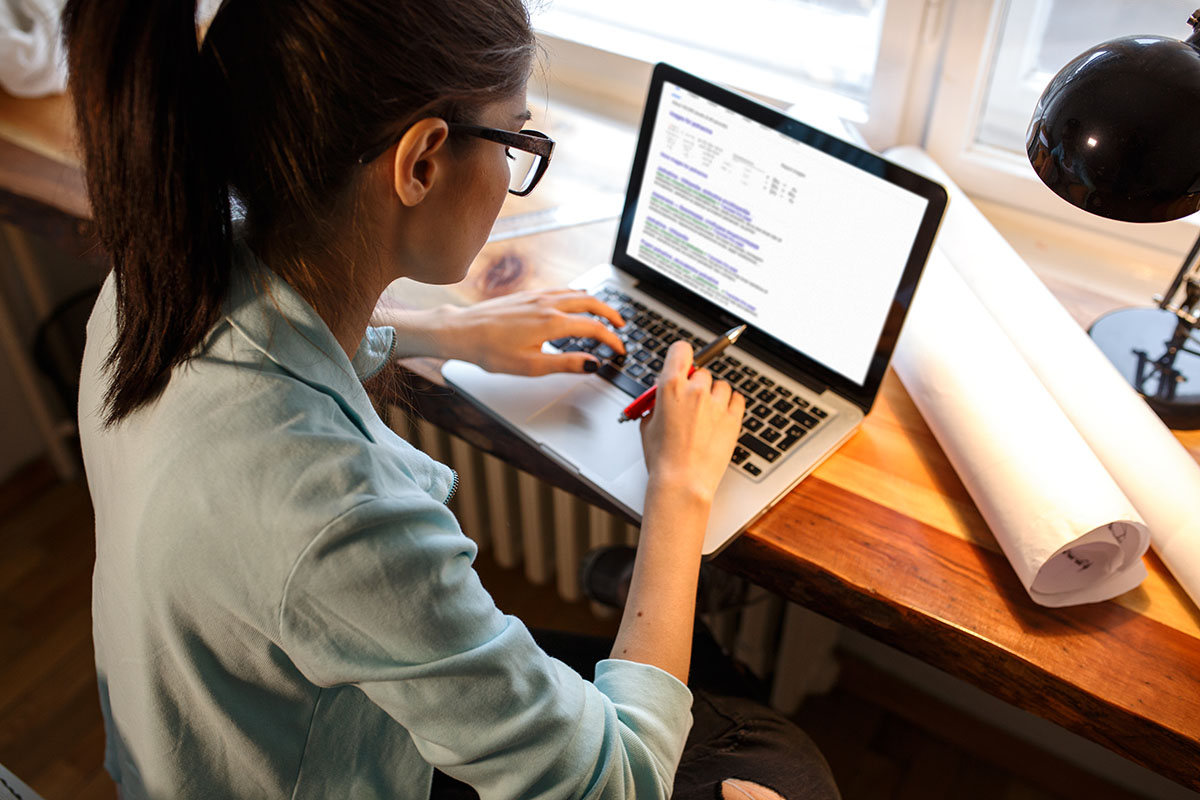young woman working on laptop at home