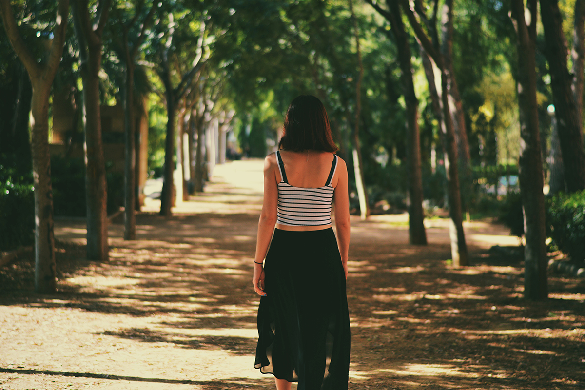 A woman walks through a park in Barcelona, Spain.