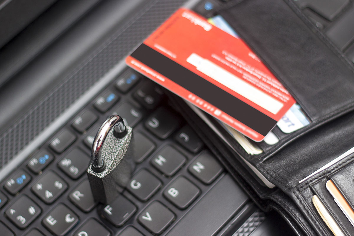 High angle view of wallet with security lock on computer keyboard.