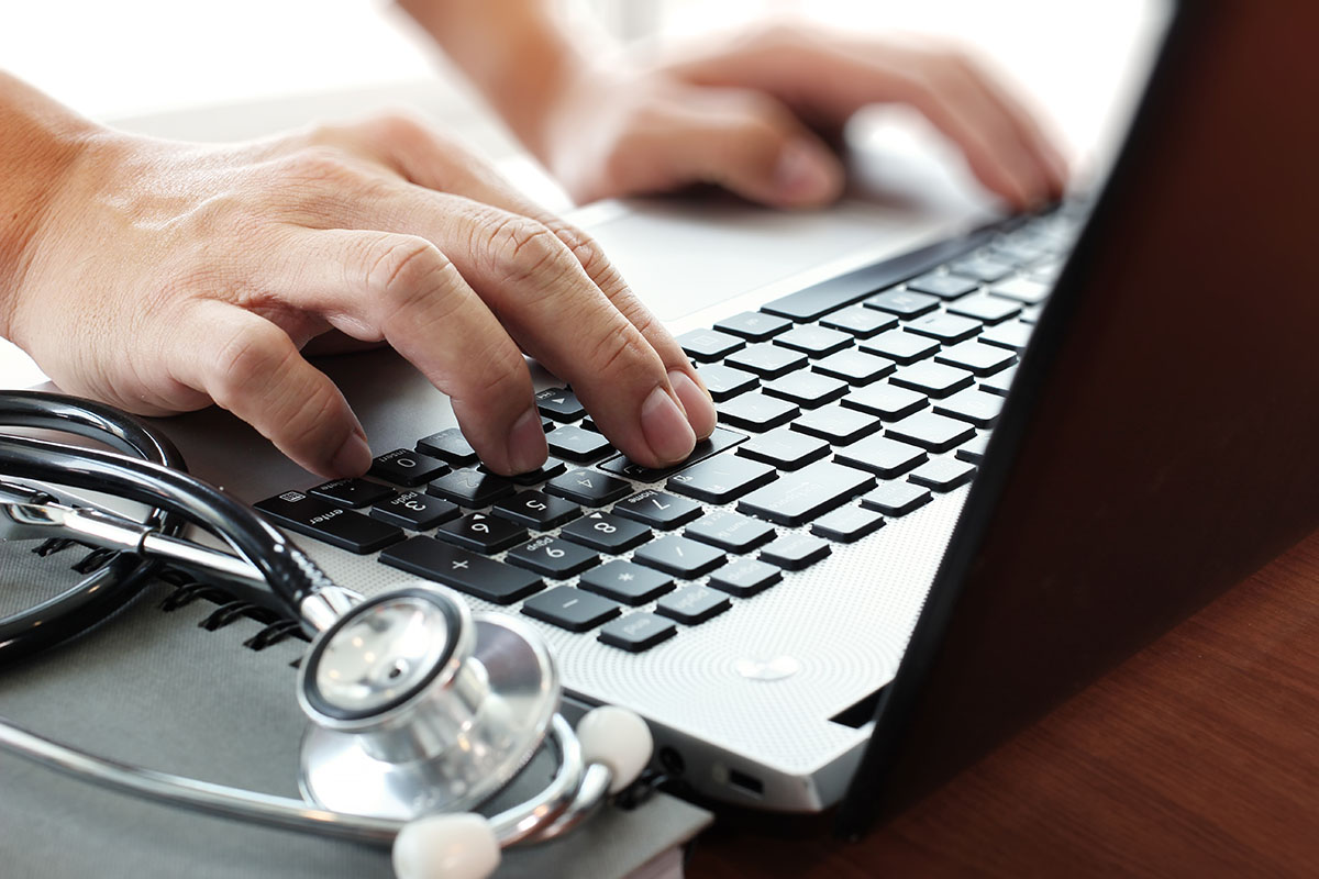 Doctor working with laptop computer in medical workspace