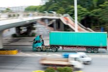A teal truck drives in traffic.