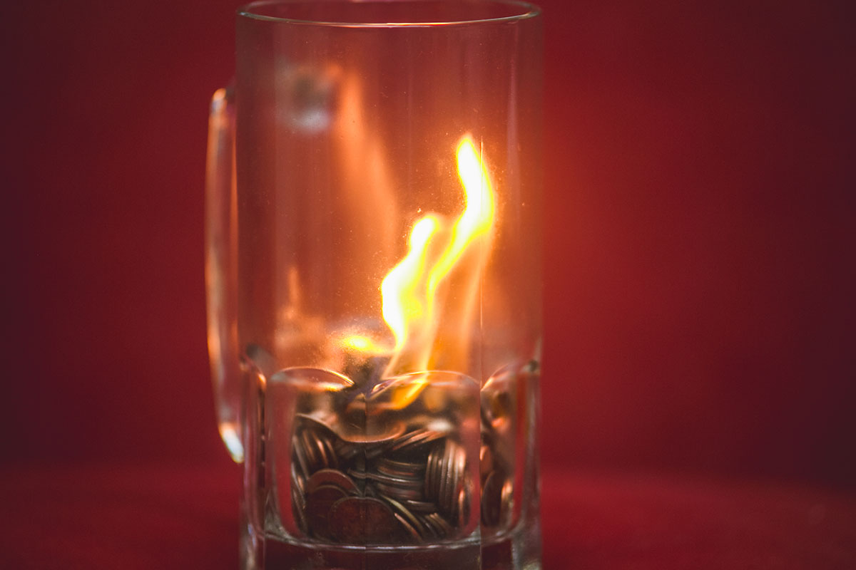 Coins are set on fire in a beer mug.