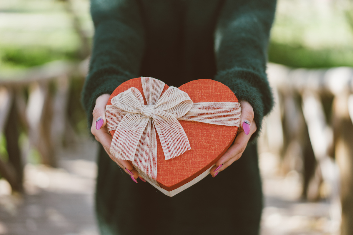 woman holding red heart shaped box