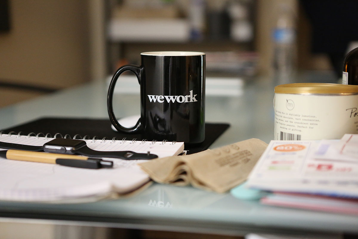 coffee mug and journal sitting on desk
