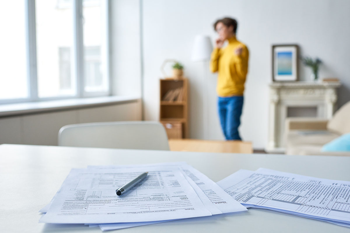 business papers and pen on white table at home of businesswoman
