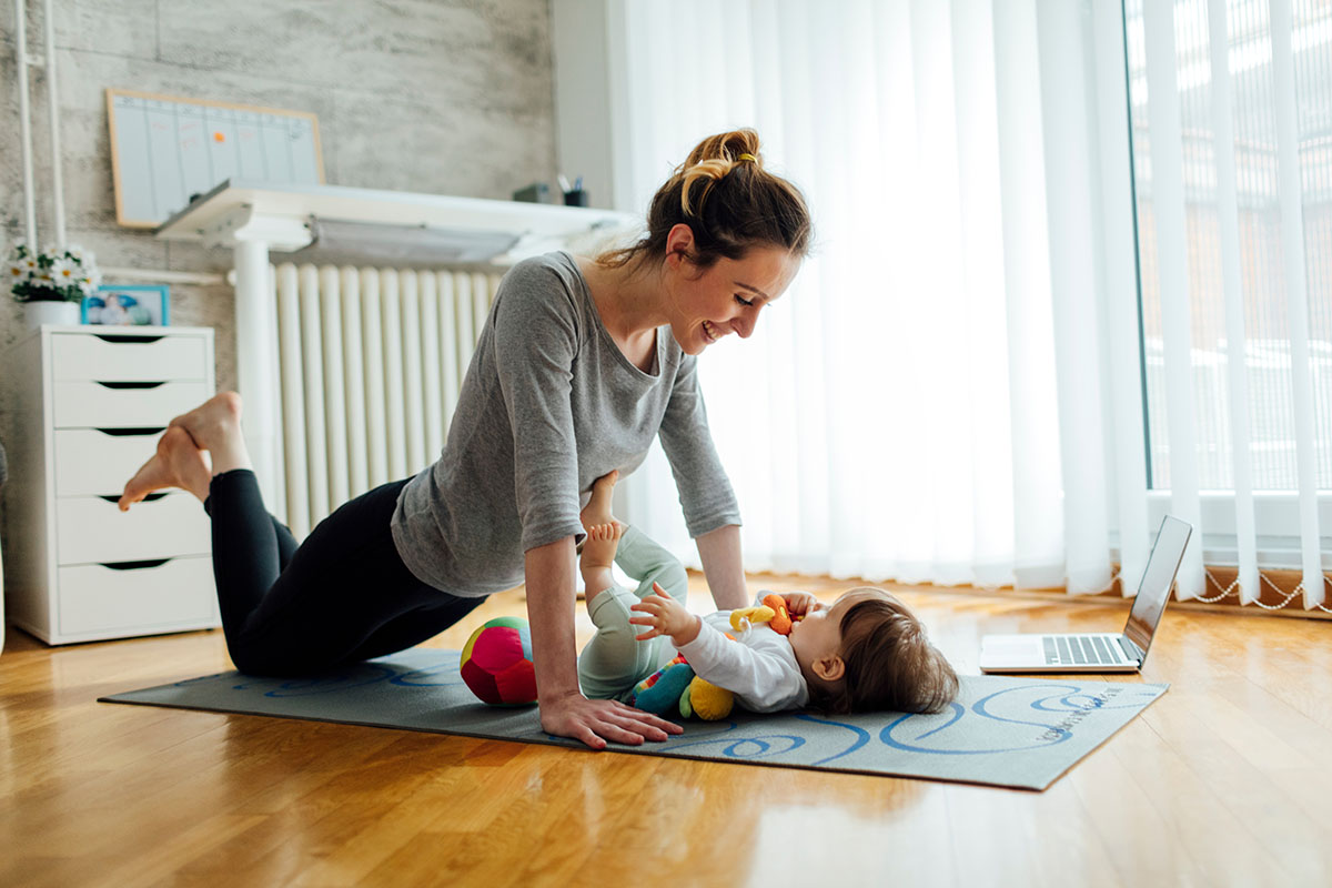 Mother Exercise With Her Baby At Home