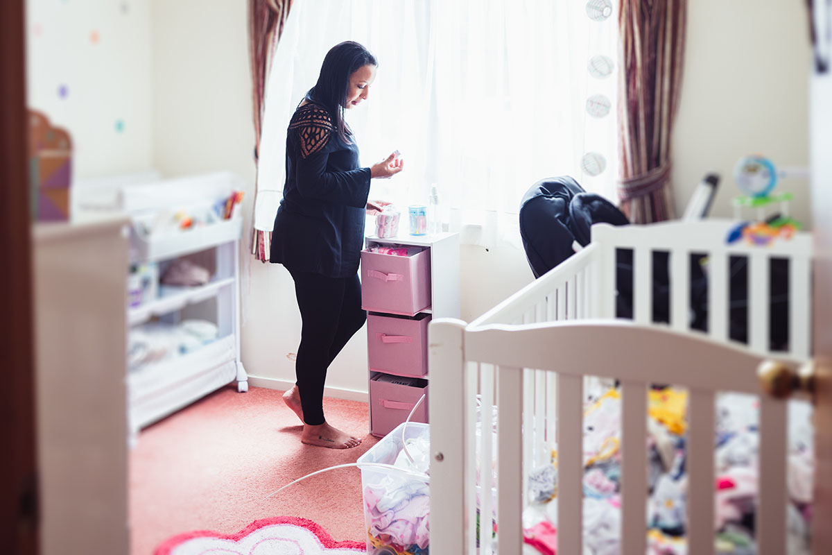 Pregnant woman dressing up room for their new baby.