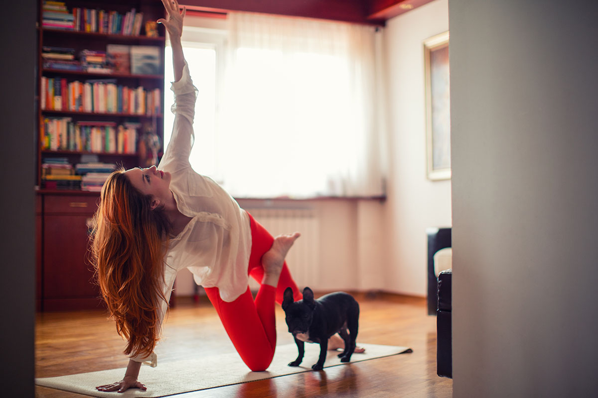 redhead woman practicing yoga at her home.