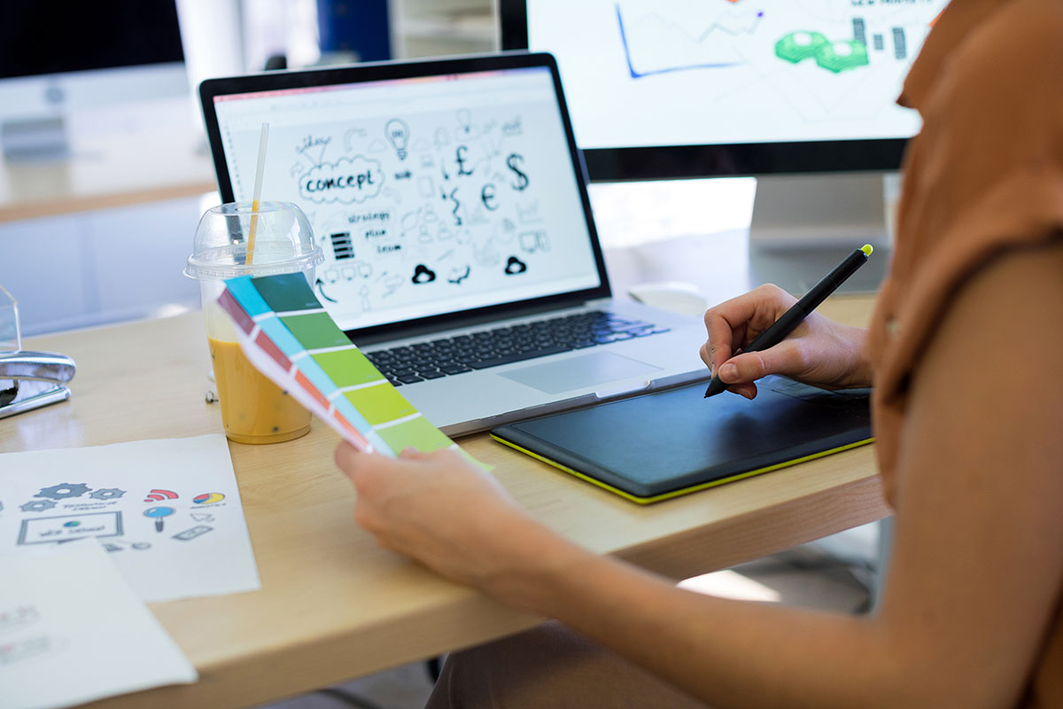 Close-up of female executive working over graphic tablet at her desk in office