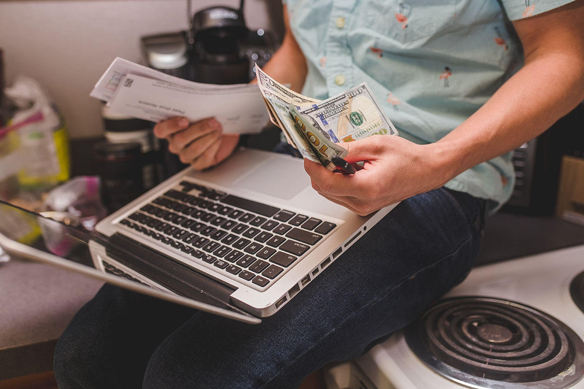 Derek Mateo sorts money while paying bills