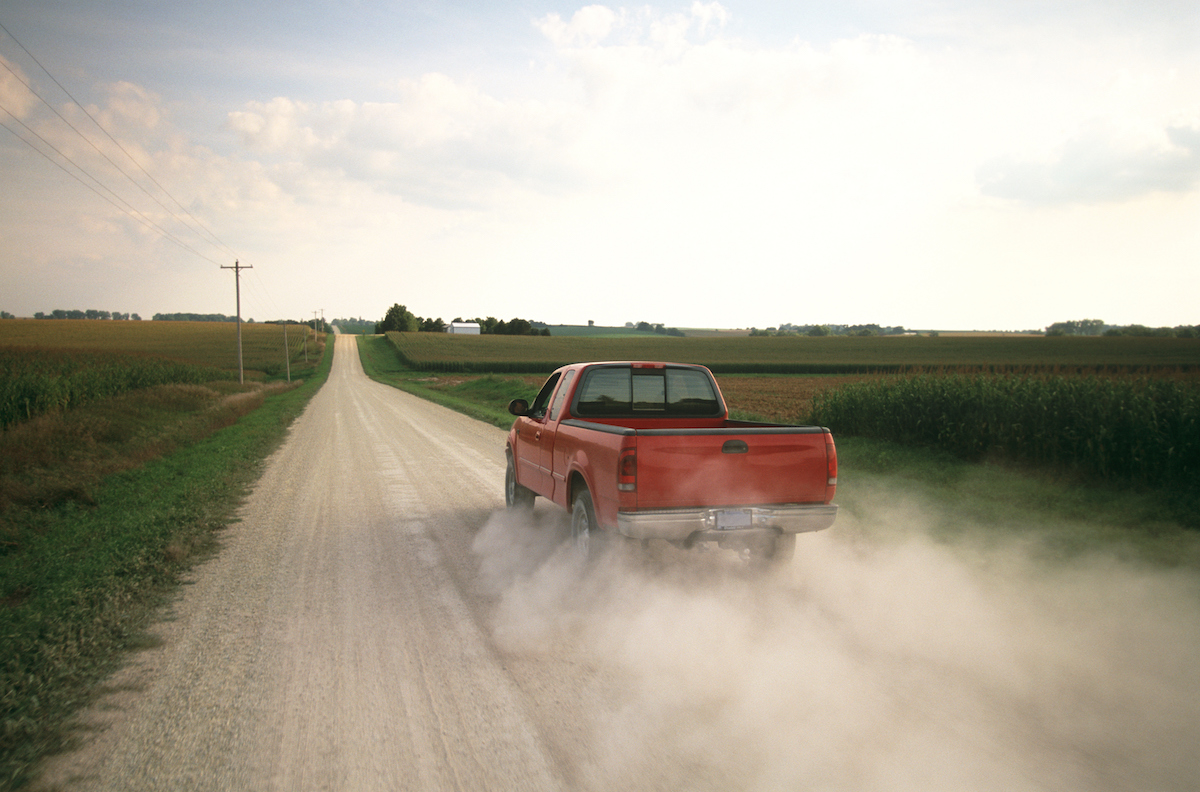 Red pickup truck on a dusty rural road