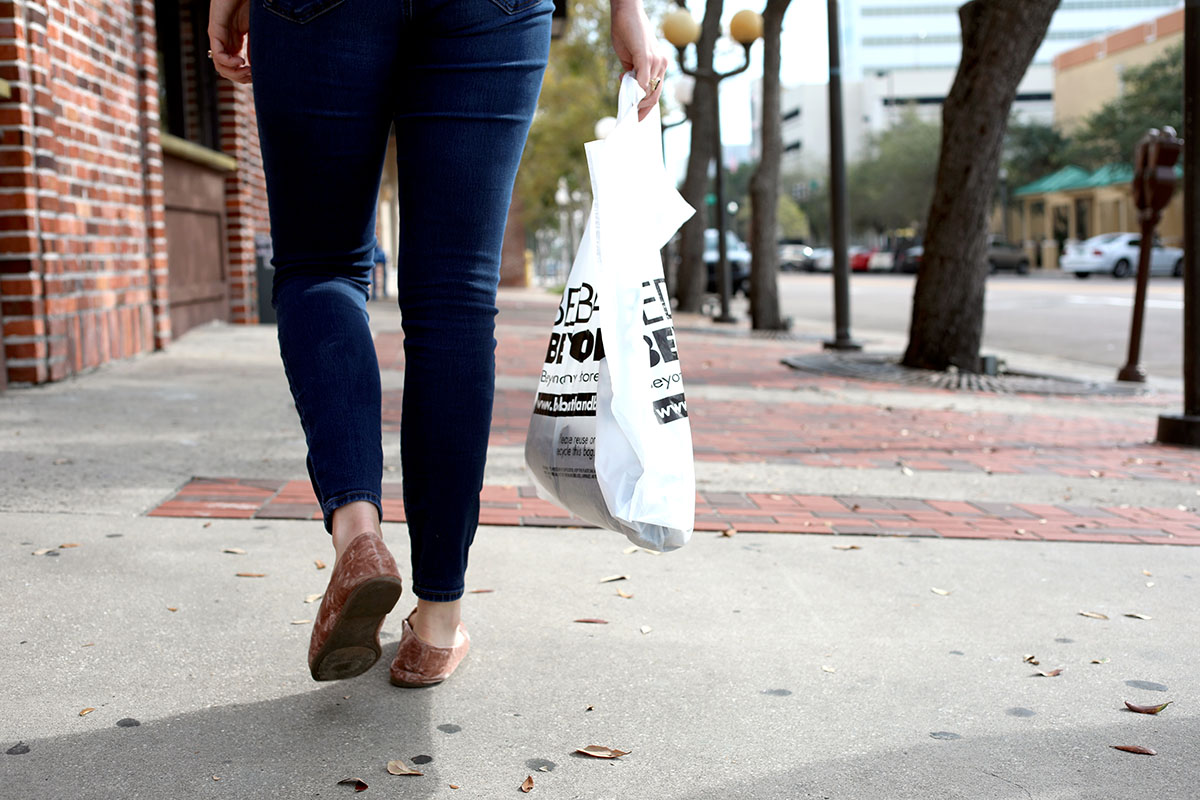 woman holding bed bath and beyond shopping bag
