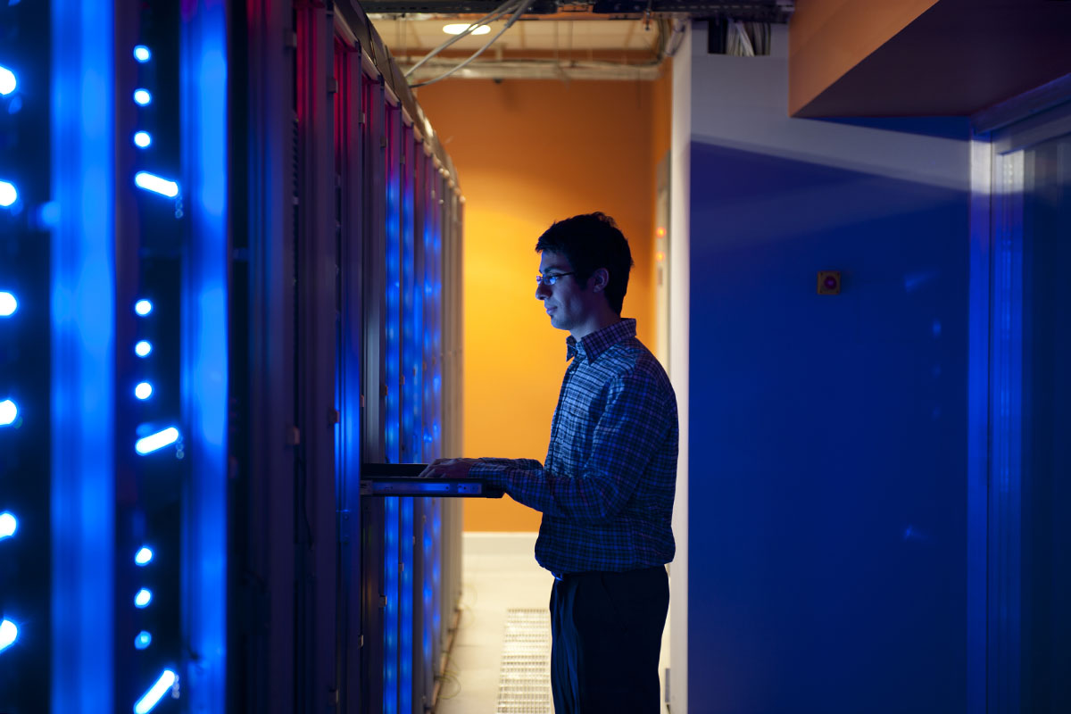 Modern interior of server room in datacenter. IT Engineer in Action Configuring Servers