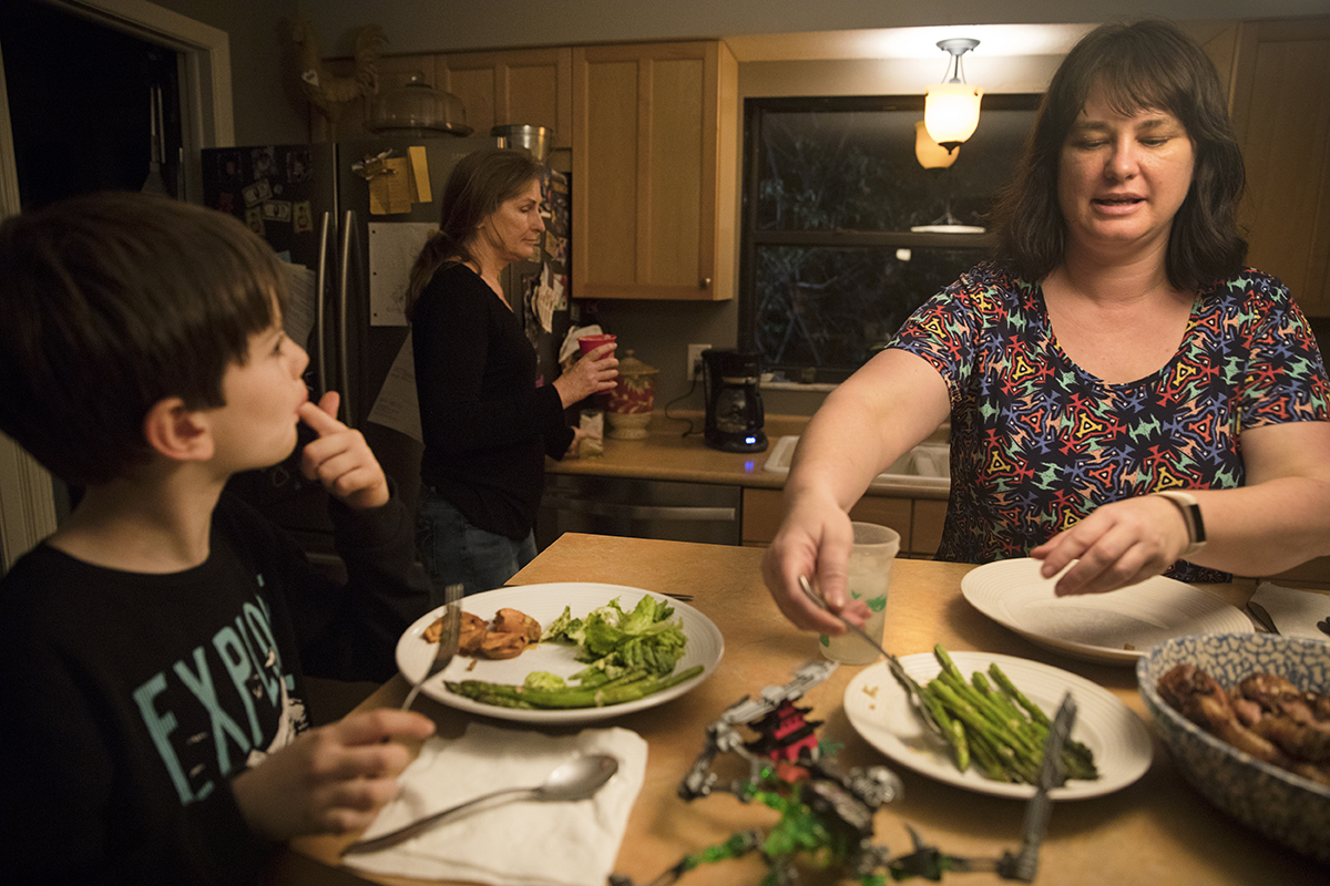 A family gets ready to eat dinner at their home.