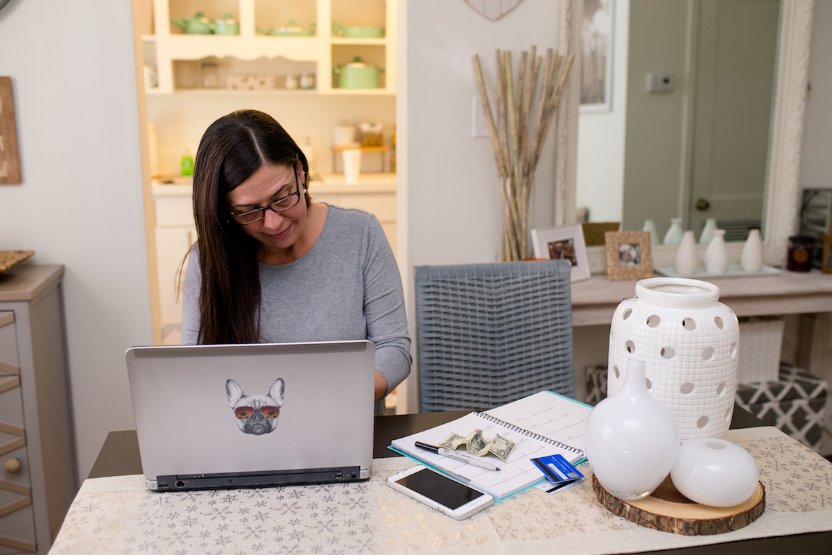 Woman works on her laptop at a desk in her home.