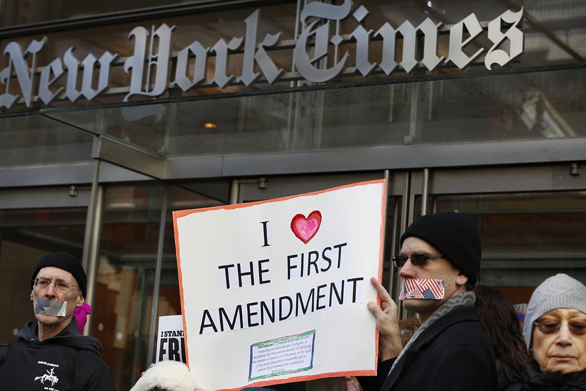 Protesters hold signs during a show of solidarity with the press in front of The New York Times building on Feb. 26, 2017, in New York.