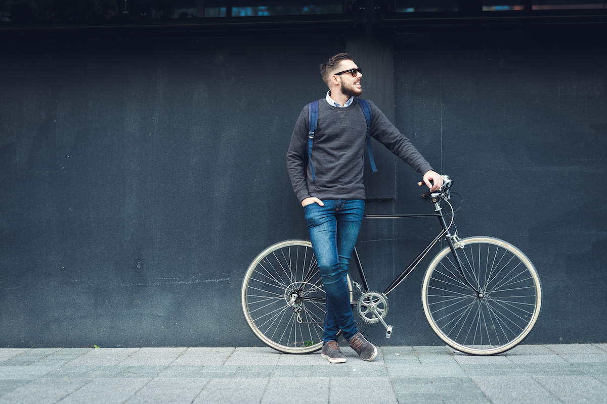 a person posing next to his bicycle.