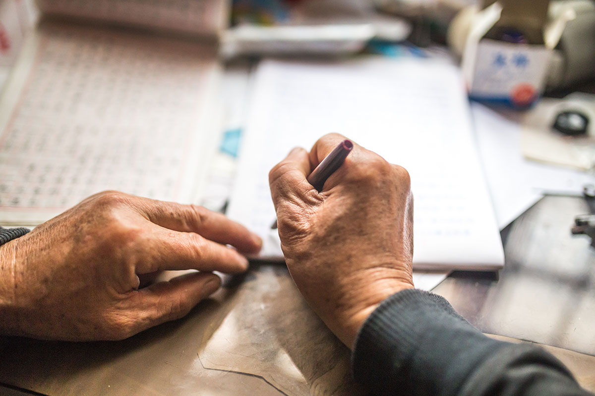 Old grandfather writing letters at home in winter