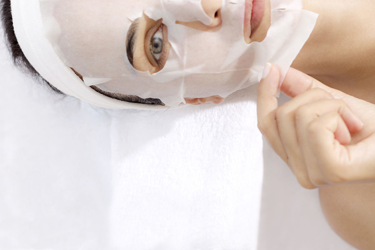 woman taking off a facial mask