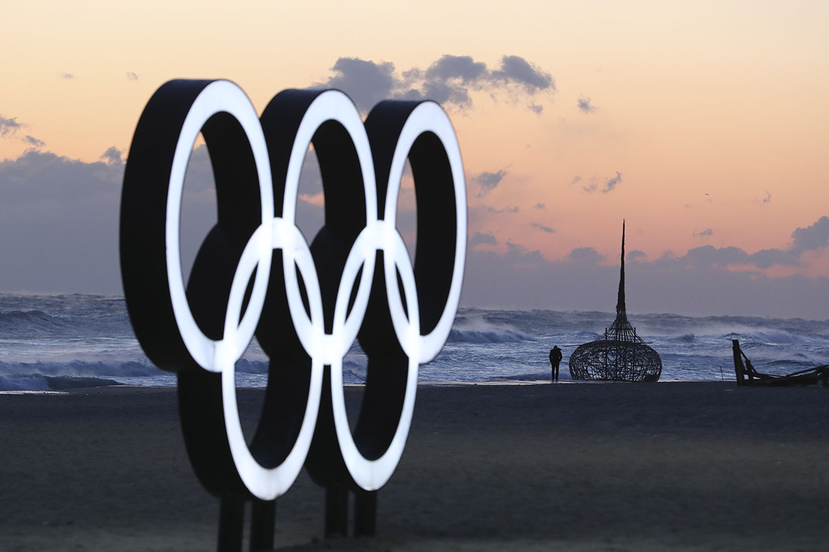A visitor walks along the beach near the Olympic Rings in Gangneung, South Korea