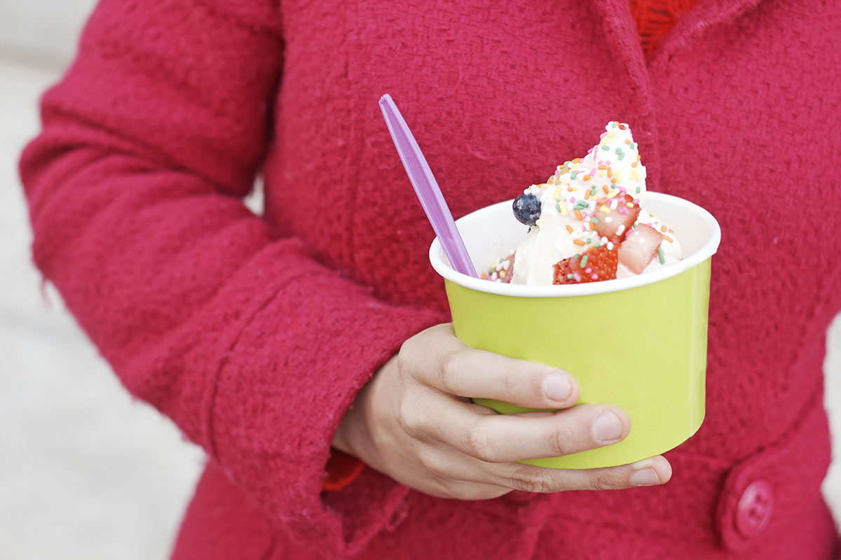 woman holding cup of frozen yogurt