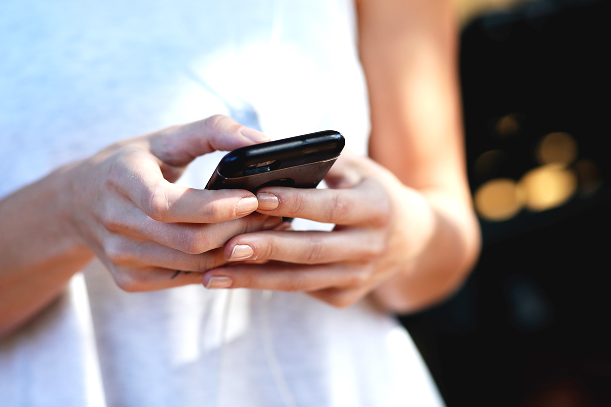 A woman looks at her cell phone