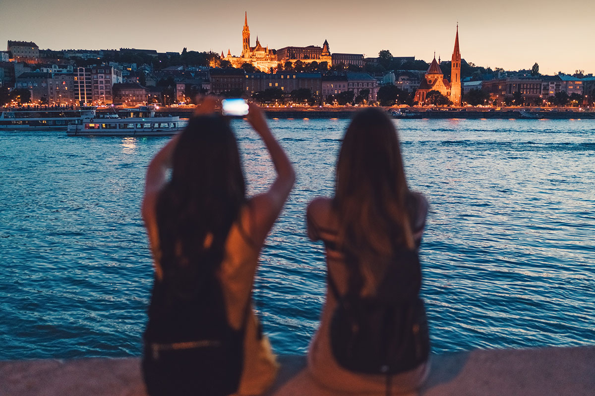 Rear view of two women at evening taking photos of Matthias church