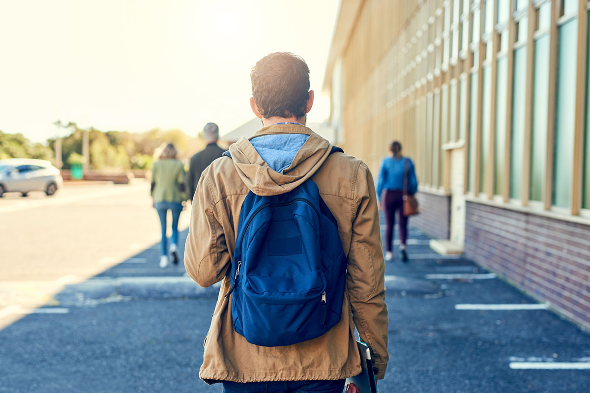 Shot of a college student between classes on campus grounds