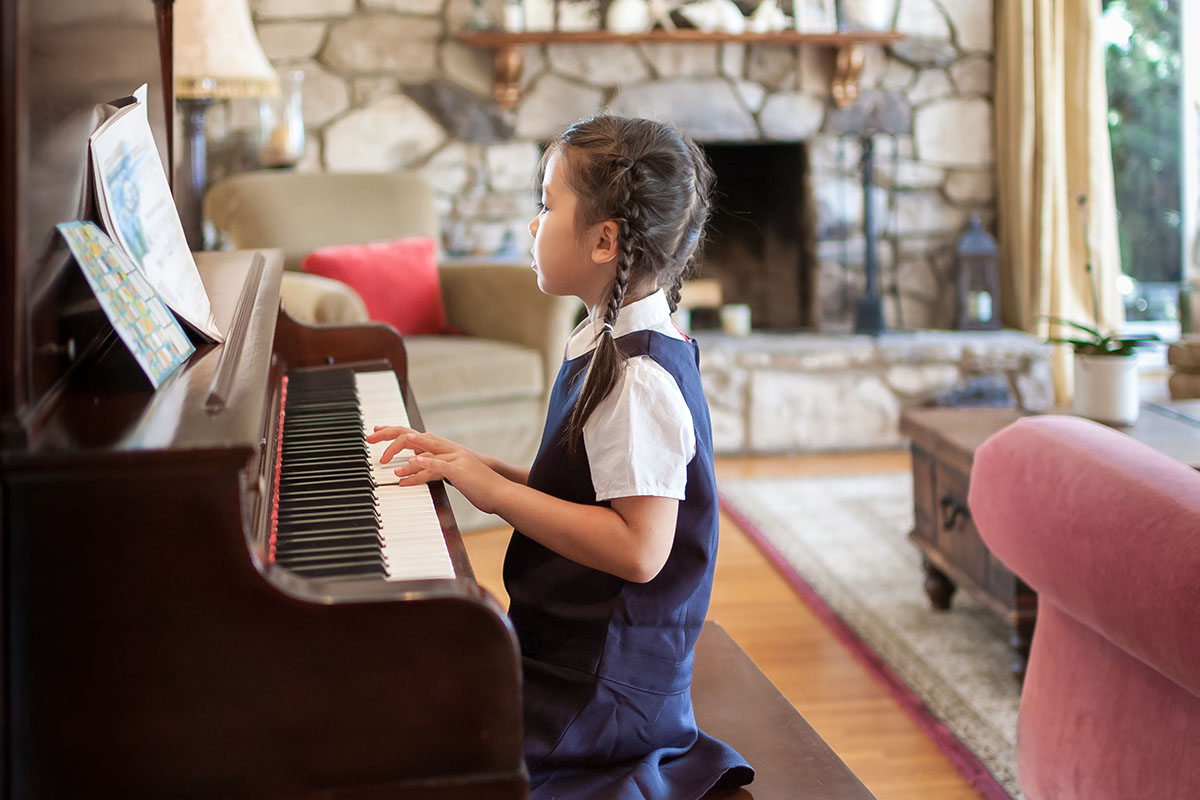 little girl playing the piano at home