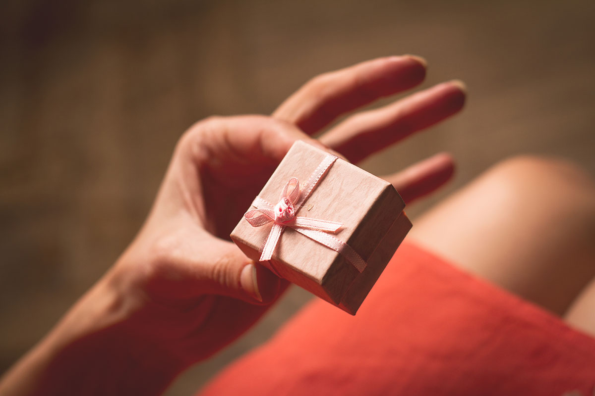 Woman holding in her hand a very small pink gift