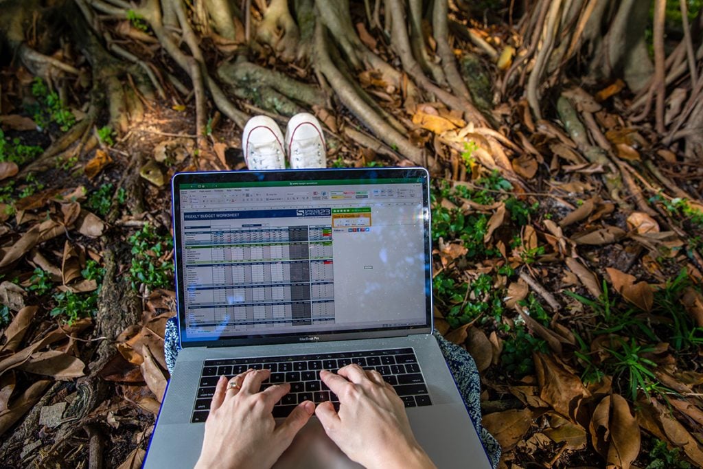 A woman types in her fiances into a budget spreadsheet
