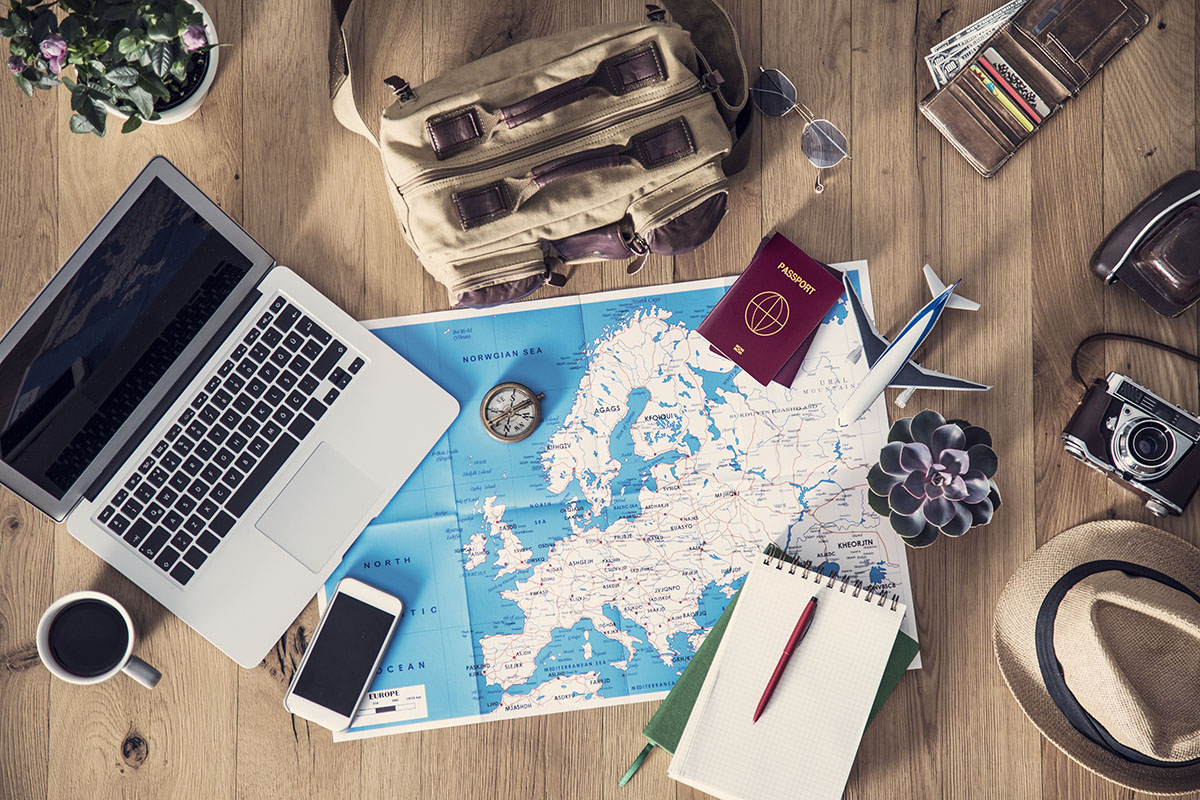 travel map and notes on desk with laptop