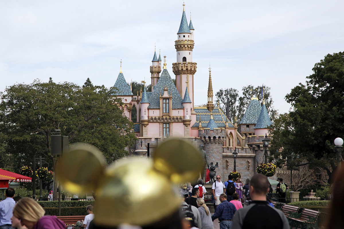 Park visitors walk around Disneyland in Anaheim, Calif.