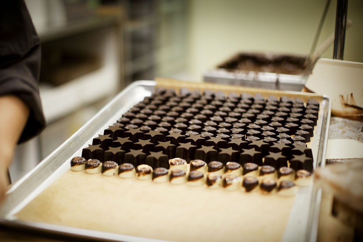 Chef filling a tray of artisanal stuffed chocolate.