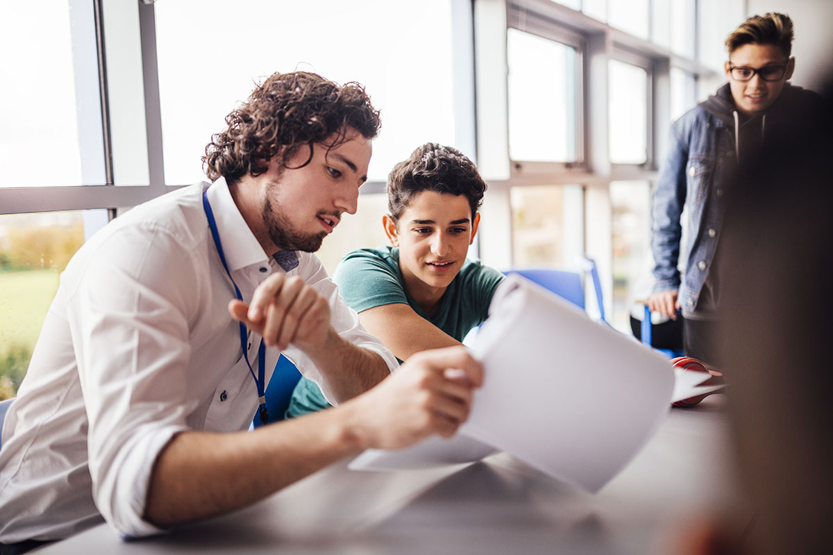 Teacher showing a student some results on his paperwork.