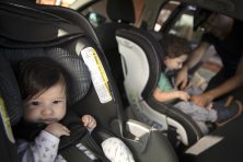 A baby and a toddler in car seats.