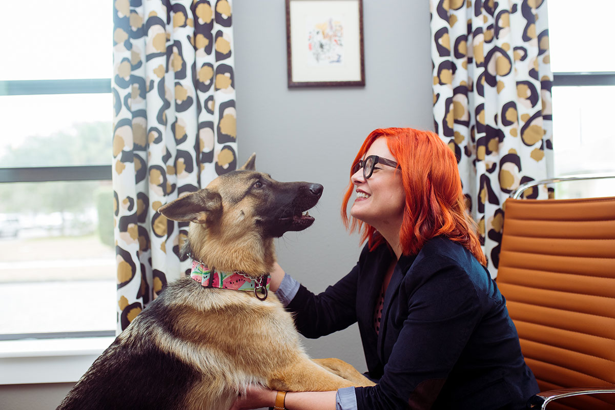 Lisa Gilmore interacts with her dog during the work day in St. Petersburg, Fla.