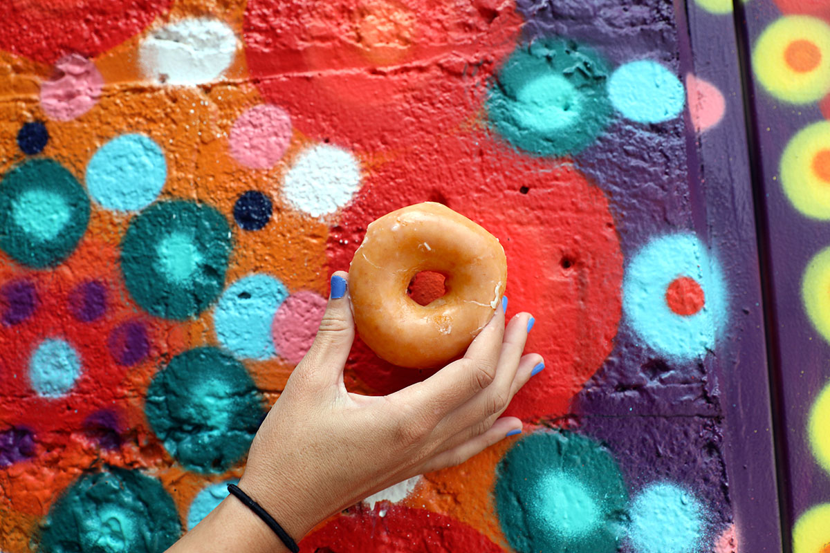 krispy kreme donuts in front of painted mural
