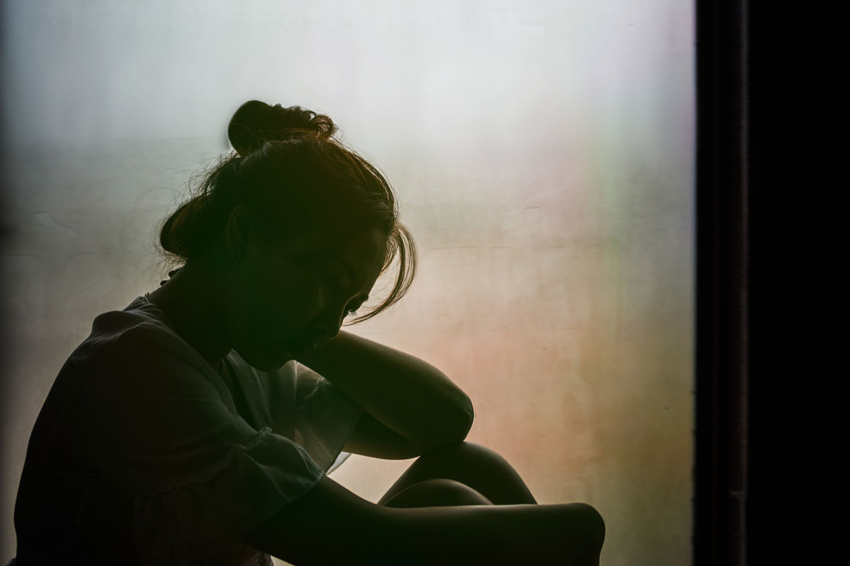 silhouette of girl sitting in the window