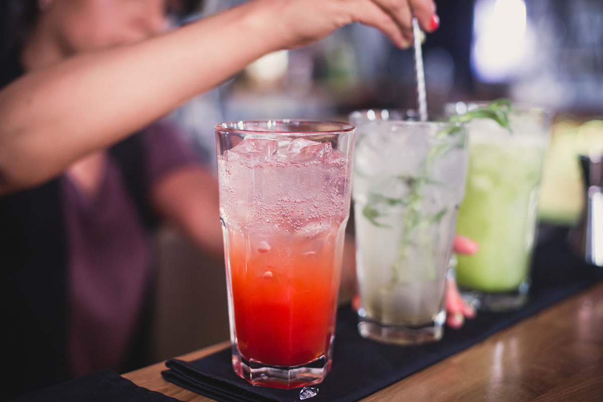 Beautiful line of glasses and shots with different colored cocktails