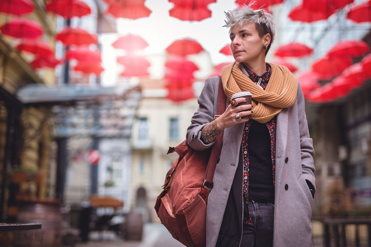 woman walking outside while holding coffee