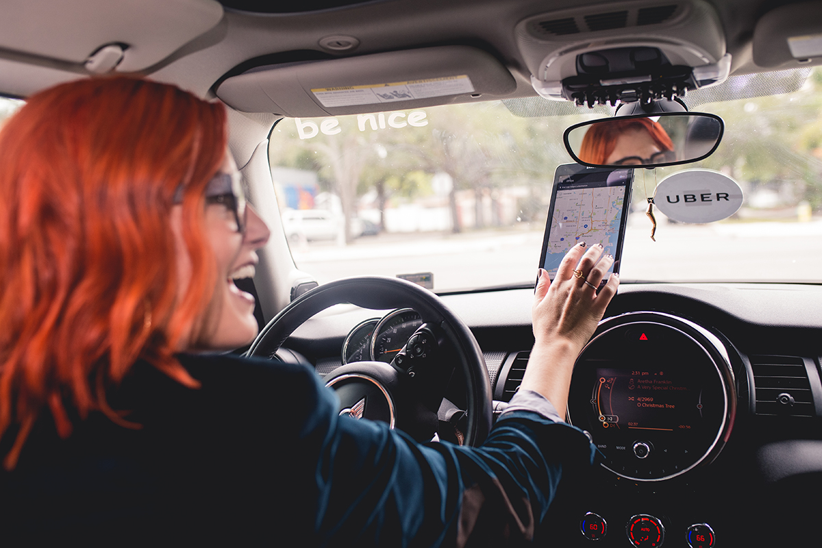 A woman gets ready to pick up a person while driving for Uber.