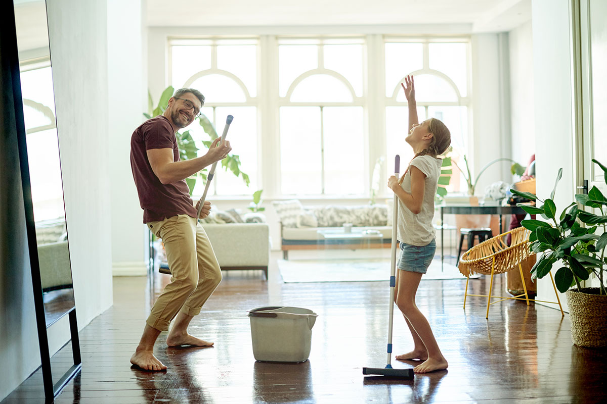 man and his daughter mopping the floors in their home as part of their spring cleaning