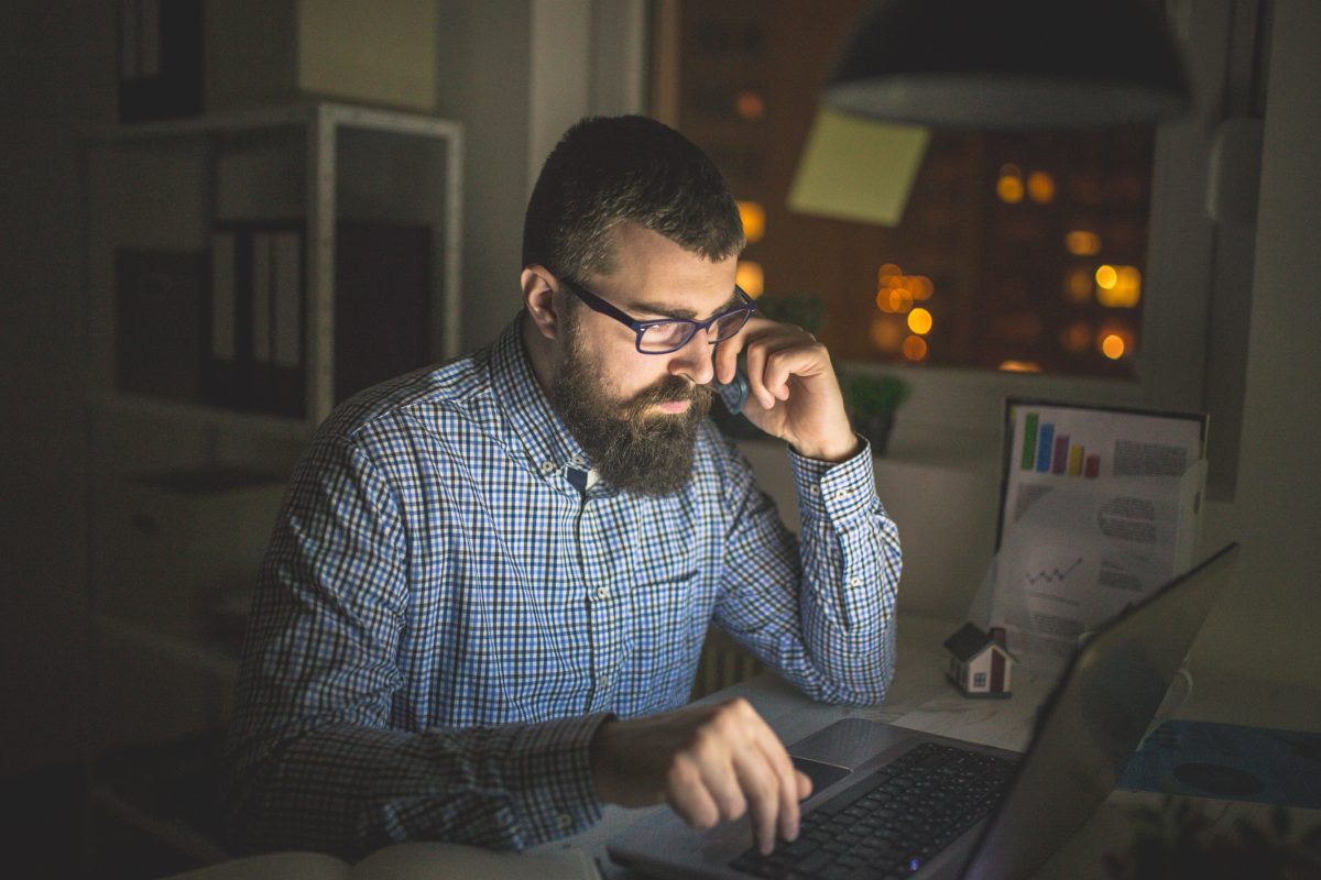 Young man working late night in his office