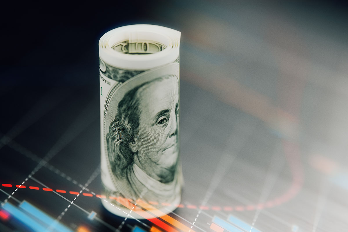 Rolled American one hundred banknote with graphical elements over dark background.