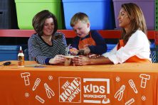 Two women help a child build a birdhouse at The Home Depot.