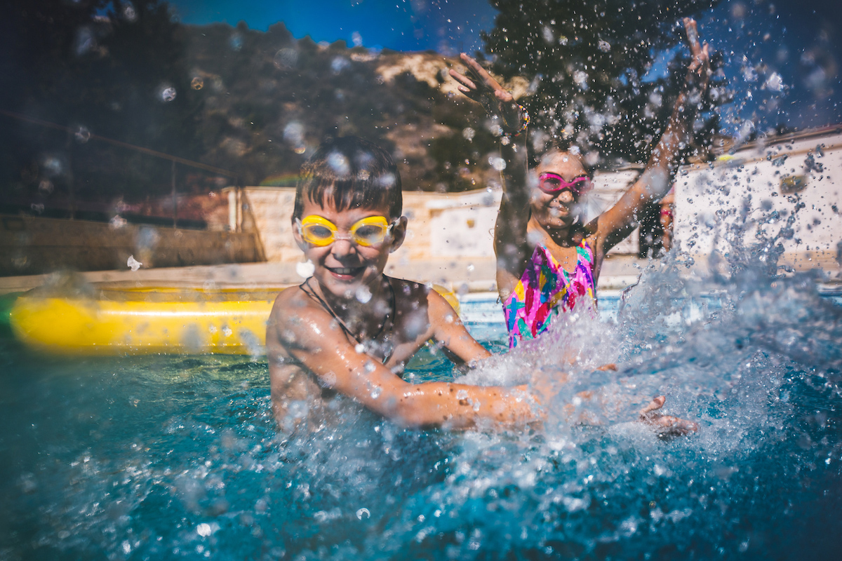 Young brother and sister swimming in a pool
