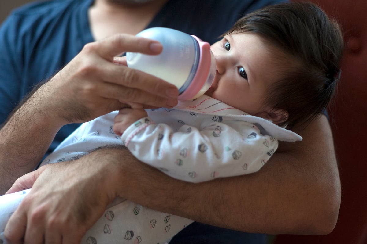 Marceline Avila drinks pumped breastmilk at home with her stay-at-home father in St. Petersburg, Fla. Sharon Steinmann/The Penny Hoarder