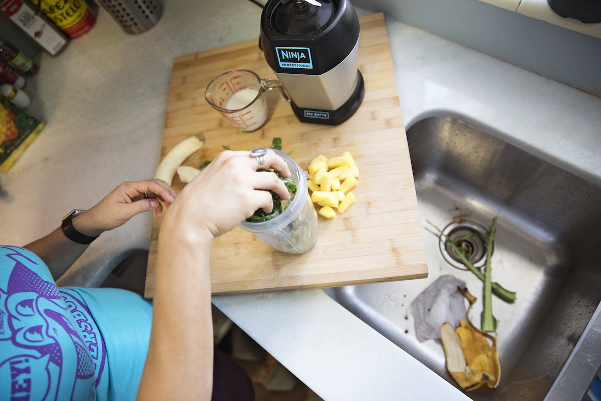A woman prepares a smoothie in her kitchen