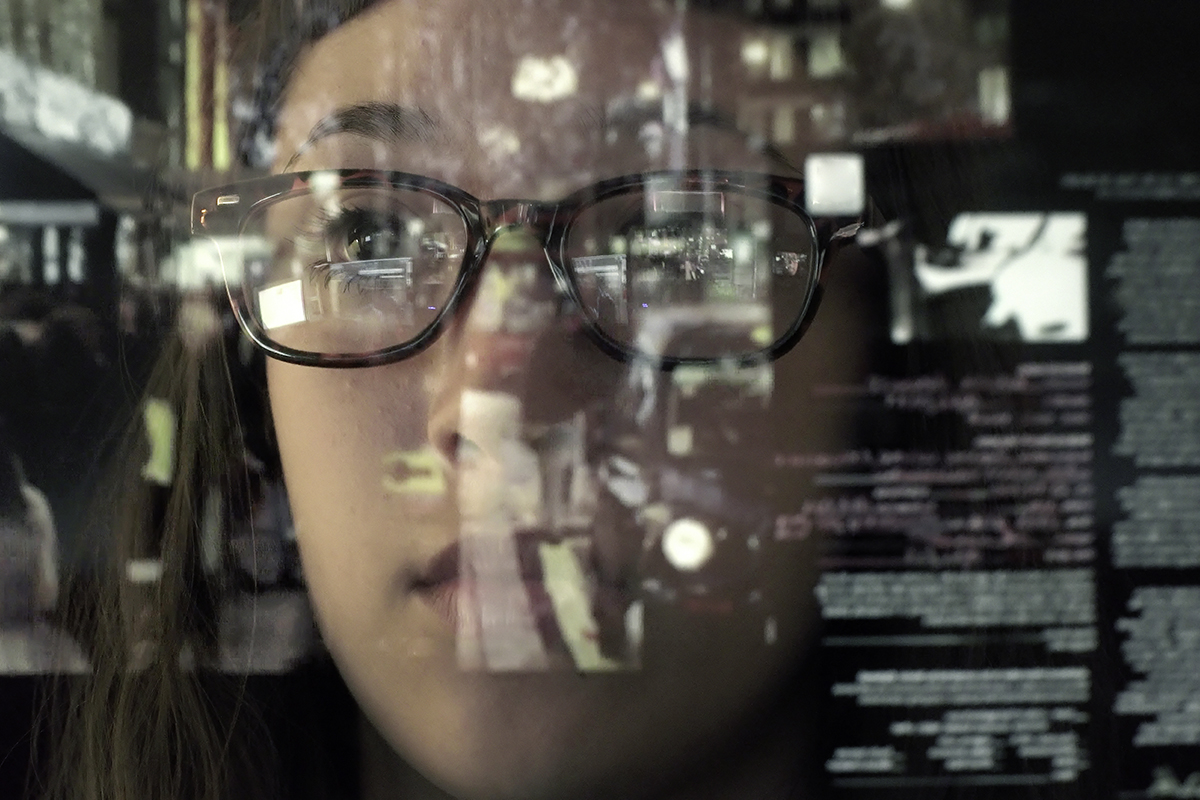 A woman's face with computer screen reflections